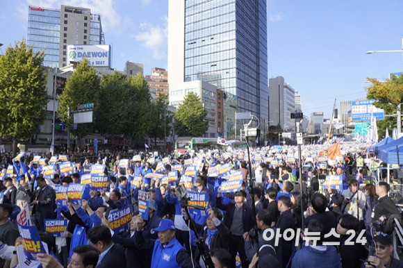 지난 2일 서울역 인근에서 진행된 '김건희·윤석열 국정농단 규탄·특검촉구 국민행동의 날' 집회에 참여한 민주당 소속 국회의원·당원·시민들이 피켓을 머리 위로 드는 모습. [사진=라창현 기자]