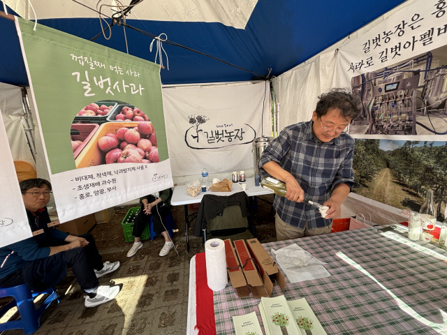 ▲ 길종각 씨가 제9회 홍천사과축제장에서 애플사이더 시음회를 진행하는 모습.