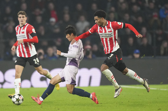 PSV Eindhoven's Malik Tillman, right, tries to stop Girona's Kim Min-su during a Champions League match at Philips Stadium in the Netherlands on Tuesday. [AP/YONHAP]