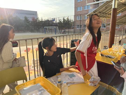 지난 4일 경기 화성시 송린초 학생들이 늘봄학교 스포츠 프로그램의 일일강사로 참여한 육상선수 김민지로부터 옷 등에 사인을 받고 있는 모습. 송린초 제공