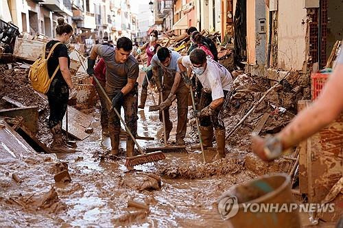 스페인 수해 현장서 시민들이 진흙더미를 걷어내고 있다. [로이터 연합뉴스 자료사진. 재판매 및 DB 금지]