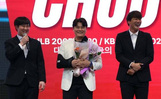 SSG 랜더스 추신수(가운데)가 7일 인천 연수구 경원재 앰배서더 호텔에서 열린 은퇴 기자회견에서 최정(왼쪽)과 김광현에게 축하를 받고 있다. 추신수는 어깨 수술을 받아 보호대를 차고 나왔다. [뉴스1]