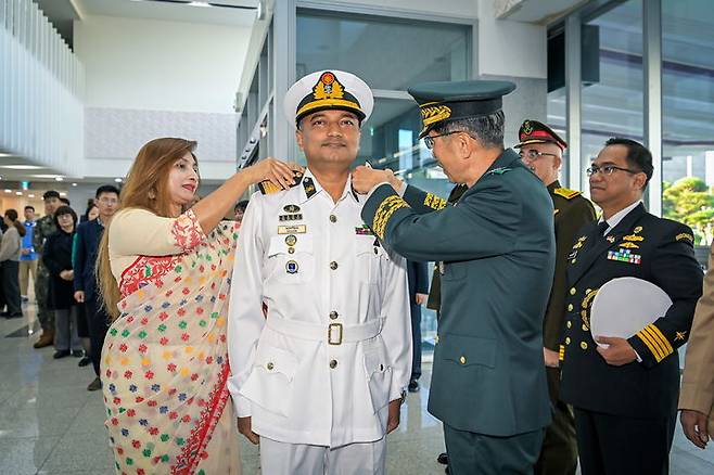 [논산=뉴시스]임기훈 국방대학교 총장이 8일 국방대 안전보장대학원에 수학 중인 외국군 수탁장교 방글라데시 탄짐(TANZIM FARUQ) 해군 대령에게 장군 계급장을 달아주고 있다. (사진=국방대 제공) 2024.11.08. photo@newsis.com *재판매 및 DB 금지