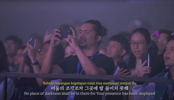 지난 8월 인도네시아 수라바야에서 열린 위러브 집회에 모인 현지인들이 스마트폰으로 찬양팀을 촬영하는 모습.