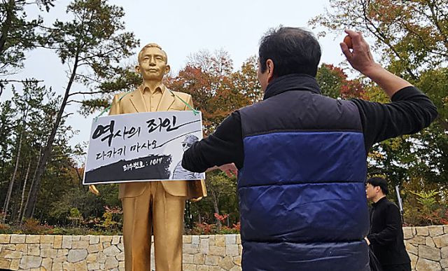 10일 오후 경북 경산시 영남대학교에서 영남대 민주동문회원이 대학 내 설치된 박정희 동상에 계란을 던지고 있다. 연합뉴스