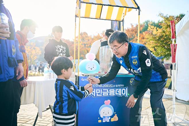 이재연 서민금융진흥원 원장이 지난 10일 인천축구전용경기장에서 진행된 서민금융데이 행사 부스에서 어린이 축구팬에게 서금원 캐릭터인 '포용이' 모양의 솜사탕을 전달하고 있다. (서금원 제공)