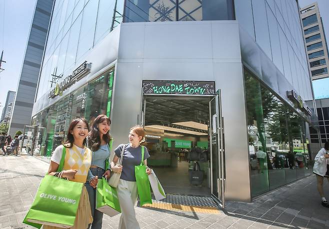 Foreigners pass by the Olive Young Hongdae Town store in Mapo District, western Seoul. [CJ OLIVE YOUNG]