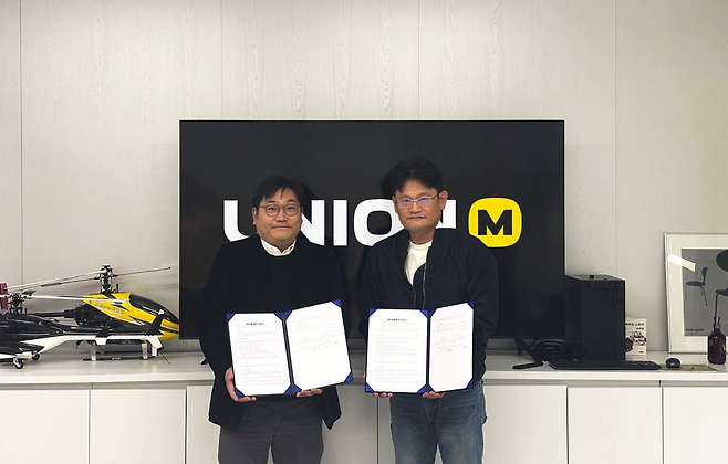 유니온모바일 이희승 대표(사진 오른쪽)와 마이게임인터랙티브 오성원 대표(왼쪽)가 '앙코르 라이프' 게임 서비스 협력을 위한 업무 제휴 협약서를 교환하고 있다(사진 제공=유니온모바일).
