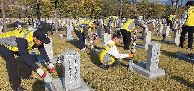 [서울=뉴시스] 한신공영 한신孝플러스봉사단 임직원 및 가족들이 현충원 봉사활동을 진행하고 있다. 2024.11.12 (사진 제공=한신공영) photo@newsis.com *재판매 및 DB 금지