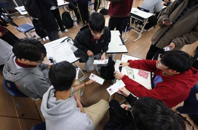 2025학년도 대학수학능력시험 예비소집일인 13일 서울 종로구 중앙고등학교에서 3학년 학생들이 교사로부터 수험표를 배부받은 뒤 확인하고 있다. 뉴스1