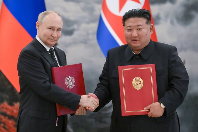 North Korean leader Kim Jong-un, right, and Russian President Vladimir Putin sign joint documents during a ceremony at the Kumsusan State Guest House in Pyongyang on June 19. [TASS/YONHAP]