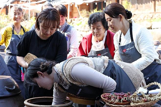 장독대에 차곡차곡 메주 넣기 (담양=연합뉴스) 김혜인 기자 = 13일 오전 전남 담양군 창평면 기순도 발효학교에서 명인과 함께 일본인 관광객들이 전통장 만들기 체험을 하고 있다. 2024.11.13 in@yna.co.kr