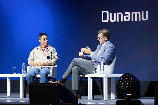 Dunamu CEO Lee Sirgoo (left) and Michael Casey, former chief content officer at CoinDesk, discuss how blockchain technology can change the real world at the Upbit D Conference, held at a Seoul hotel on Thursday. (Dunamu)