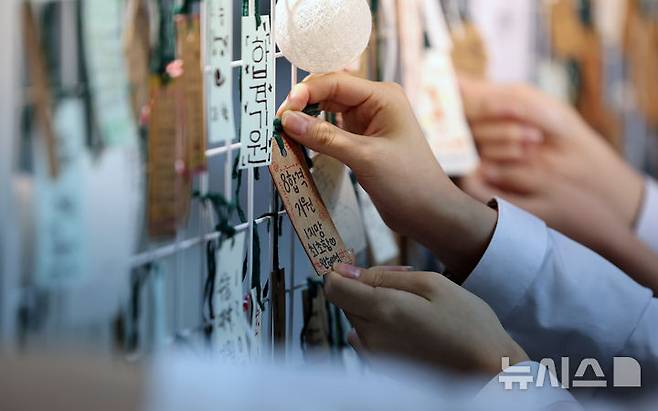 [대구=뉴시스] 이무열 기자 = 2025학년도 대학수학능력시험을 일주일 앞둔 7일 대구 북구 매천고등학교에서 미술중점반 2학년 후배들이 수능 응원 게시판에 수험생 선배들의 고득점을 기원하는 응원 메시지를 매달고 있다. 2024.11.07. lmy@newsis.com