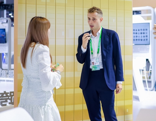 Jules Thevenon, an international affairs public relations manager, talks to a visitor at the Lin-gang Exhibition Area.