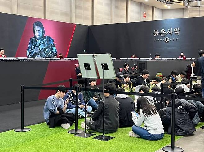 펄어비스 부스 앞에 앉아 '붉은사막' 시연을 기다리는 관람객들. 이날 펄어비스 부스는 인파가 쏠려 대기가 중단되는 일이 생기기도 했다.ⓒ데일리안 이주은 기자