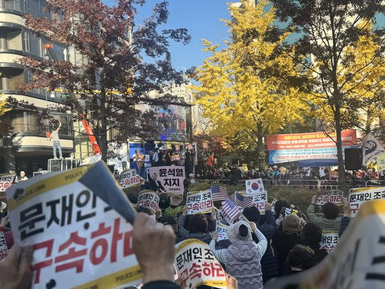 이재명 민주당 대표의 유죄 소식이 전해지자, 법원 앞 도로에서 열린 집회에 참석한 보수 지지자들이 다같이 자리에서 일어나 환호하고 있다. 이보람 기자