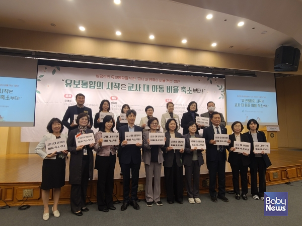 지난 11일 국회에서 열린 '성공적인 유보통합을 위한 교사 대 영유아 비율 개선 방안' 토론회. 참가자들이 '영유아 비율 개선부터'라고 쓰인 손피켓을 들고 있다. ⓒ서울시어린이집연합회