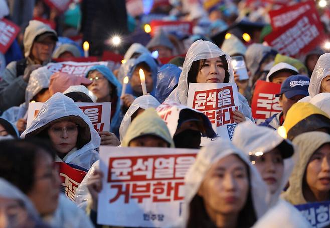 거부권을 거부하는 전국비상행동 등 시민단체 주최로 16일 오후 서울 종로구 광화문 광장 일대에서 열린 \'김건희 특검 수용, 국정농단 규명! 윤석열을 거부한다 시민행진\' 집회에서 참석자들이 손팻말과 촛불 모형을 들고 있다. 김영원 기자 forever@hani.co.kr