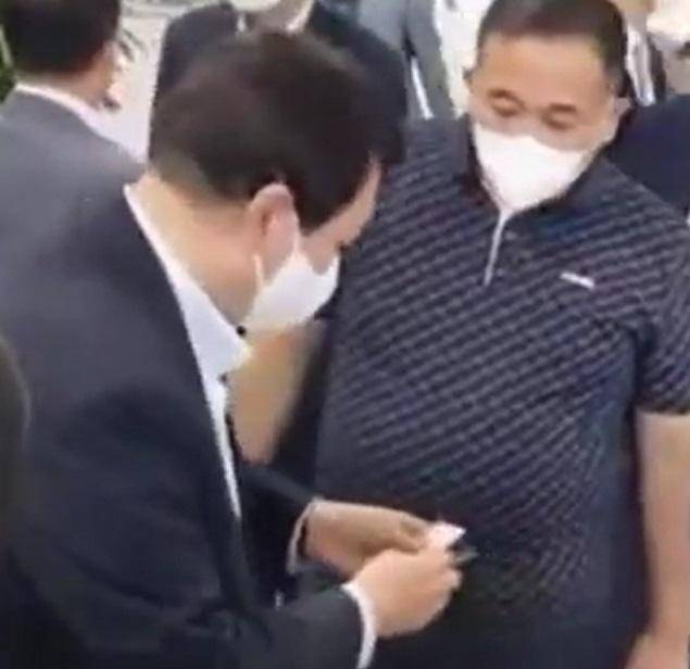 윤석열 대통령이 국민의힘 대선 후보였던 2021년 9월 18일 2022 지방선거 출마 의사를 선언한 사람 등에게 인사하는 모습을 명태균씨가 지켜보고 있다. 강혜경씨 측 제공