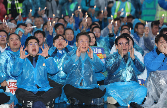 Democratic Party (DP) leader Lee Jae-myung, center, floor leader Park Chan-dae, left, and other party officials shout slogans during an anti-government rally in Gwanghwamun Square in Jongno District, central Seoul, on Saturday. [YONHAP]