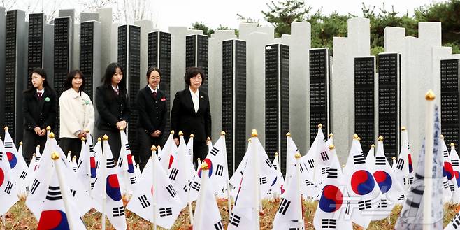 강정애 국가보훈부 장관이 17일 오전 대전 유성구 국립대전현충원 내 무후(無後) 독립유공자 추모시설인 '독립의 염원이 모이는 길'에서 열린 제85회 순국선열의 날 기념식에 참석한 뒤 대전여상 학생들과 독립의 염원이 모이는 길을 걸으며 후손·묘소 없는 무후 독립유공자 6478명의 이름을 새긴 추모 명비를 둘러보고 있다. 2024.11.17/뉴스1 ⓒ News1 김기남 기자