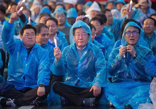 지난 16일 오후 더불어민주당이 서울 광화문광장 인근에서 개최한 ‘김건희 윤석열 국정농단 규탄·특검 촉구’ 집회에서 참석자들이 비가 내리는 가운데 우비를 입고 구호를 외치고 있다. /장련성 기자