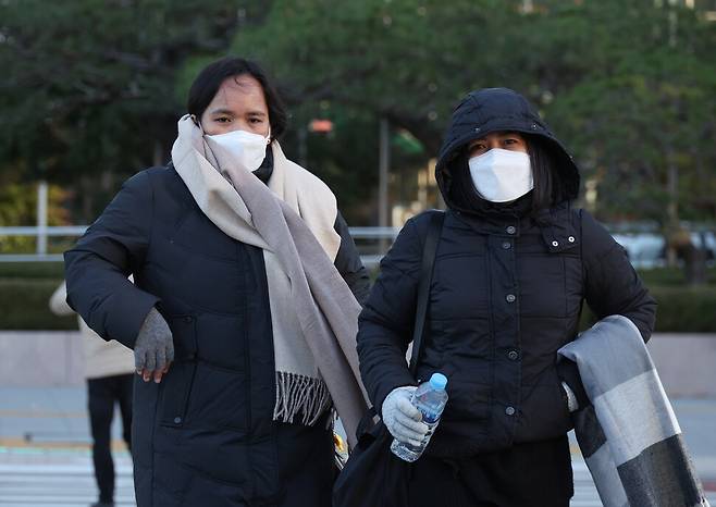 전국적으로 아침 기온이 영하권으로 떨어지고 바람도 강하게 분 18일 오전 서울 종로구 광화문네거리에서 관광객들이 따뜻한 옷차림으로 길을 건너고 있다. 김혜윤 기자