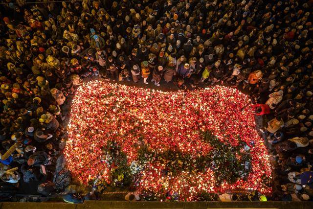 체코 프라하에서 17일 벨벳혁명 35주년을 맞아 시민들이 1989년 나로드니 광장에서 경찰의 강경진압에 희생당한 학생들을 추모하며 촛불을 밝히고 있다. 체코 민주화 혁명인 '벨벳혁명'은 1989년 시민과 학생 수십만 명이 거리로 나와 민주화를 요구하는 집회를 열고 공산정권을 무너뜨린 후 같은 해 12월 28일 반체제 단체 '시민포럼'을 이끌었던 바츨라프 하벨이 대통령에 오르게 된 사건을 말한다. 이후 연방을 이루고 있던 체코와 슬로바키아는 1993년 분리됐다. 프라하=EPA 연합뉴스