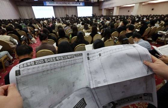 15일 서울 광진구 세종대학교에서 열린 종로학원 2025 정시 합격점수 예측 및 전략 설명회에서 학부모들이 정시모집 배치 참고표를 보며 설명을 듣고 있다. 뉴스1
