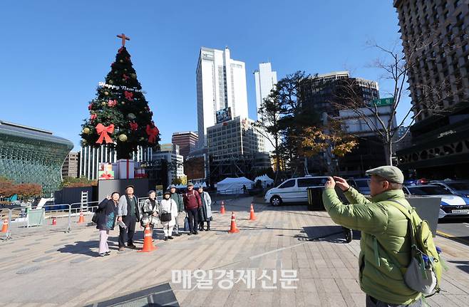 크리스마스를 한 달여 앞둔 18일 오후 서울시청 앞 서울광장에 설치된 대형 크리스마스 트리 앞에서 시민들이 사진을 찍고 있다.2024.11.18[이충우기자]