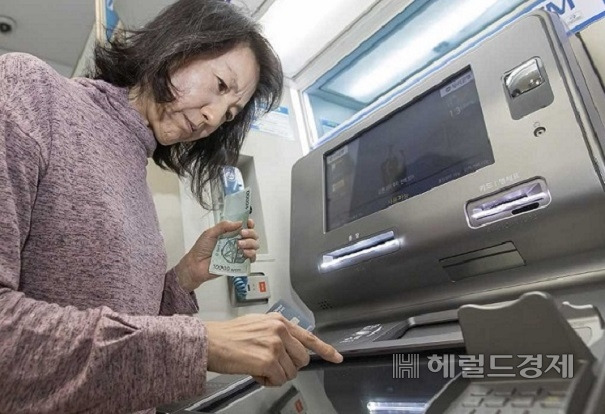 은행들이 비용 감축 차원에서 점포, 현금자동입출금기(ATM) 등 대면창구를 갈수록 줄이고 있어 노년층의 금융 접근성이 떨어지고 있다. 한 어르신이 ATM을 이용하고 있다. [헤럴드DB}