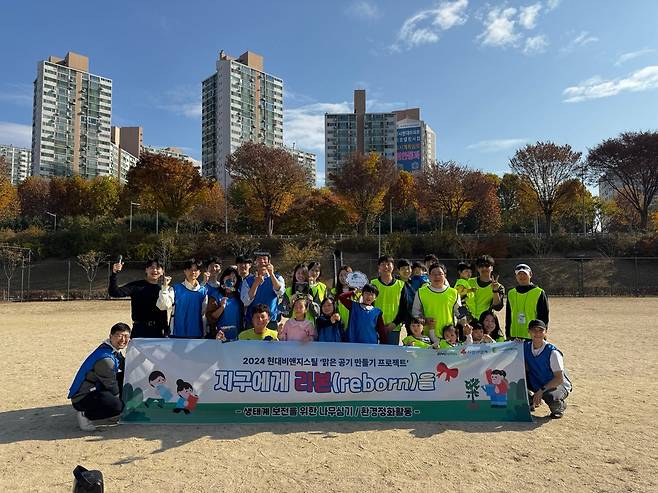 16일 현대비앤지스틸 임직원 및 가족, 자원봉사자들이 광나루한강공원에서 플로깅 행사 기념촬영을 하고 있다. [현대비앤지스틸 제공]