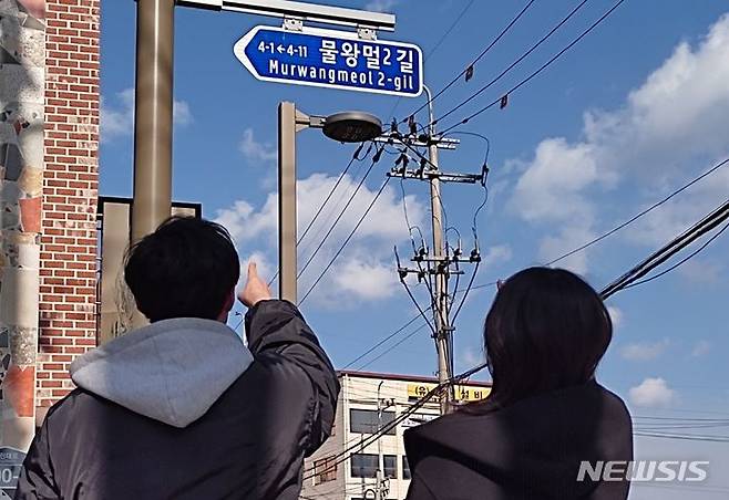 [전주=뉴시스]윤난슬 기자 = 전북 전주시에 설치된 도로명판을 시민들이 쳐다보고 있다. (사진=전주시 제공)