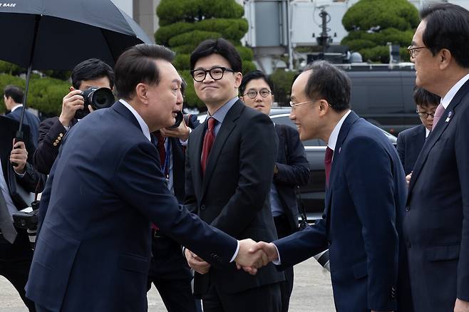 윤석열 대통령이 11월14일 성남 서울공항에서 31차 아시아태평양경제협력체(APEC) 및 19차 주요 20개국(G20) 정상회의 참석을 위해 출국하며 환송 나온 국민의힘 추경호 원내대표와 악수하고 있다. 가운데는 한동훈 대표. ⓒ대통령실 제공 