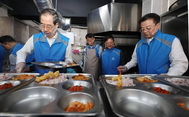 한덕수 국무총리(왼쪽)와 방기선 국무조정실장(오른쪽)을 비롯한 총리실 직원들이 19일 오후 서울 영등포구에 위치한 무료급식소 토마스의 집을 찾아 배식 봉사활동을 하고 있다. /연합뉴스