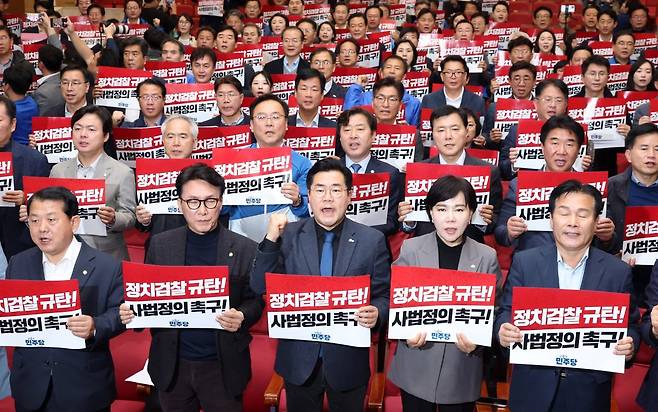 이재명 대표 1심 선고 다음날인 16일 오후 2시 서울 국회의원회관 대회의실에서 열린 더불어민주당 전국지역위원장-국회의원 비상 연석회의에서 박찬대 원내대표(앞줄 가운데) 등 참석자들이 검찰을 규탄하는 구호를 외치고 있다. 뉴시스