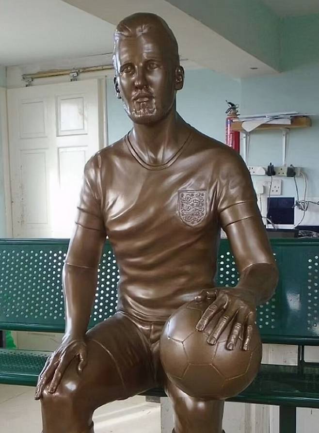 ▲ 케인은 제막식에 참석해 밝게 웃었다. 자신의 동상 옆에 직접 같은 자세로 앉아 포즈를 취하기도 했다. 케인의 만족하는 표정과 달리 팬들의 반응은 싸늘하다. 그동안 역대 최악의 축구선수 동상으로 여겨졌던 크리스티아누 호날두처럼 우스꽝스럽다는 평이다. ⓒ 가디언