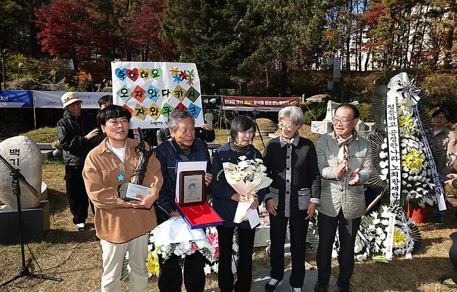 제32회 전태일노동상을 받은 김태윤 아리셀 산재피해 가족협의회 공동대표(앞줄 왼쪽)와 특별상을 수상한 오자와 다카시·구니코(왼쪽 둘째부터) 부부가 최순영 운영위원(오른쪽 둘째), 임현재 전태일재단 이사장 직무대행(맨 오른쪽) 등과 함께 기념사진을 찍고 있다.