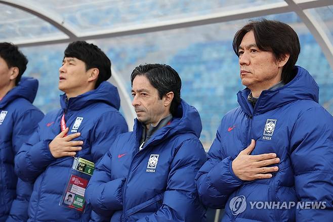 국기에 경례하는 홍명보 감독과 코치진 (암만[요르단]=연합뉴스) 황광모 기자 = 19일 오후(현지시간) 요르단 암만 국제경기장에서 열린 2026 북중미 월드컵 아시아 3차 예선 B조 한국과 팔레스타인의 경기.
    한국 축구대표팀 홍명보 감독 및 코치진이 국기에 경례하고 있다. 2024.11.19 hkmpooh@yna.co.kr