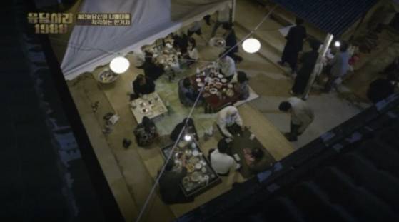 A funeral scene featured in the TV drama “Reply 1988″ shows a festive mood with all the attendees eating and drinking together with the bereaved family. [SCREEN CAPTURE]