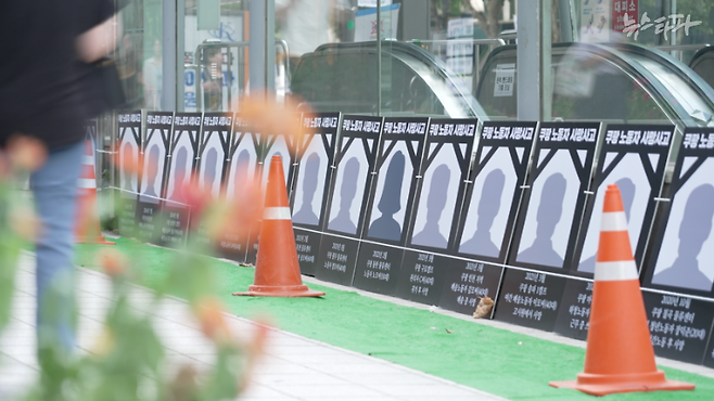 쿠팡의 재무 구조와 사업 전망 등을 따져봤을 때, 로켓배송 시스템은 불안정·미숙련·저임금·위험 일자리가 있어야 만 돈을 벌 수 있는 상황이었다. 사진은 서울 역삼동 쿠팡로지스틱스서비스 본사 앞에 놓여 있는 쿠팡 사망 노동자들의 영정 전시물.&nbsp;