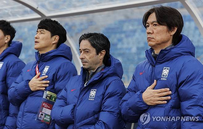 애국가 부르는 한국 축구대표팀 (암만[요르단]=연합뉴스) 황광모 기자 = 19일 오후(현지시간) 요르단 암만 국제경기장에서 열린 2026 북중미 월드컵 아시아 3차 예선 B조 한국과 팔레스타인의 경기.
   홍명보 감독을 비롯한 한국 축구대표팀 코치진이 애국가를 부르고 있다. 2024.11.20 hkmpooh@yna.co.kr