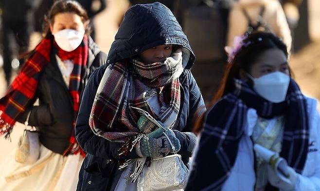 서울의 날씨가 영하권을 기록한 지난해 12월 서울 종로구 경복궁 인근에서 두꺼운 옷차림의 관광객들이 길을 지나고 있다. 연합뉴스