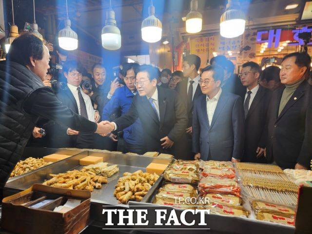 이재명 민주당 대표가 '비명계 잠룡'으로 꼽히는 김동연 경기지사와 지난 21일 경기 수원시의 한 전통시장을 방문했다. 사진은 시장에서 상인들과 인사를 나누는 이 대표와 김 지사의 모습. /신태호 기자