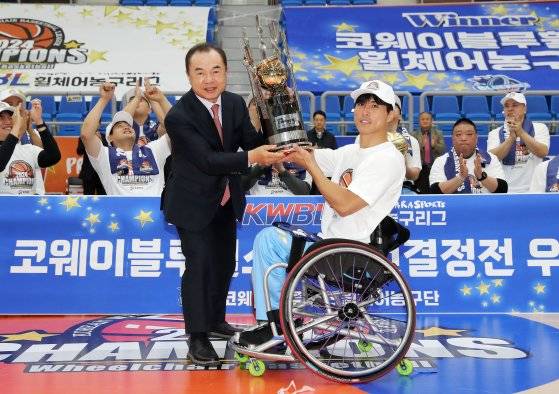 24일 챔피언결정전 3차전에서 제주삼다수를 꺾고 정상에 오른 코웨이 블루휠스 곽준성이 한국휠체어농구연맹 최욱철 총재로부터 우승 트로피를 받고 있다. 사진 한국휠체어농구연맹