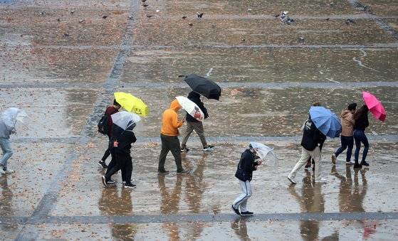 부산에 비가 내리고 강풍주의보가 발효된 26일 오전 부산 해운대구 벡스코에서 우산을 쓴 시민들이 발걸음을 옮기고 있다. 뉴스1