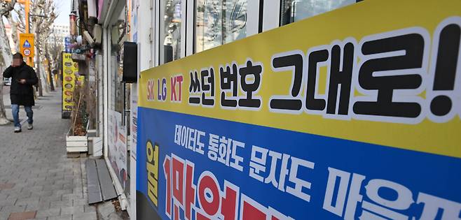 서울시내 한 휴대폰 매장 앞을 시민이 지나고 있다.   [이상섭 기자]