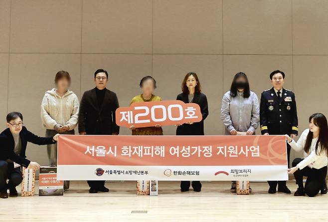 28일 서울 은평구에 위치한 서울소방학교에서 한화손해보험, 소방재난본부, 희망브릿지 관계자들이 수혜 가정과 함께 기념촬영을 하고 있다. 사진=한화손보 제공