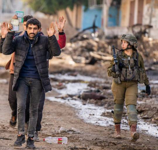 가자지구에서 연행되는 팔레스타인 무장정파 하마스 대원들을 감시하는 이스라엘 여군 병사. X 캡처